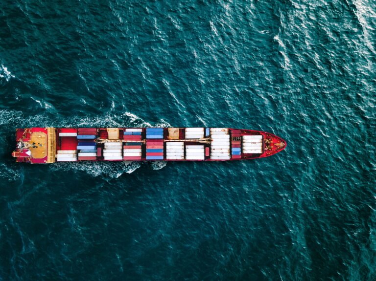 Aerial top view container ship vessel cargo carrier at blue sea.